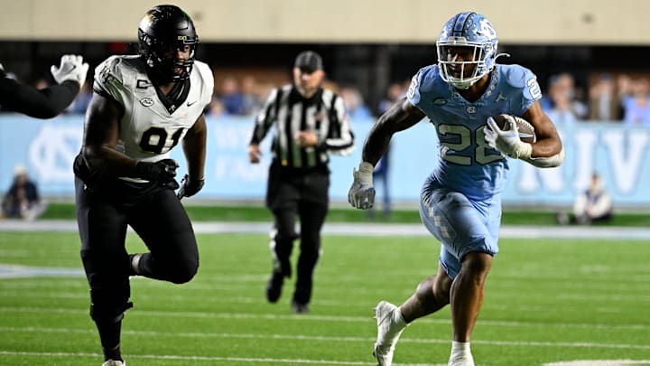 North Carolina Tar Heels running back Omarion Hampton runs as Wake Forest Demon Deacons defensive lineman Kevin Pointer defends in the third quarter at Kenan Memorial Stadium.