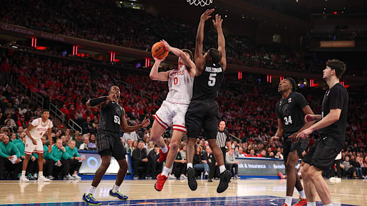 Jan 25, 2025; New York, New York, USA; Rutgers Scarlet Knights guard Jordan Derkack (0) goes to the basket as Michigan State Spartans guard Tre Holloman (5) defends during the first half at Madison Square Garden. Mandatory Credit: Vincent Carchietta-Imagn Images