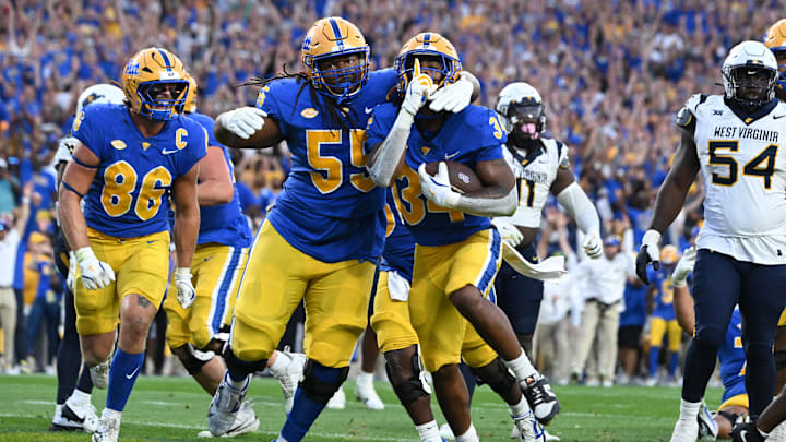 Sep 14, 2024; Pittsburgh, Pennsylvania, USA; Pittsburgh Panthers running back Derrick Davis Jr. (34) celebrates  a touchdown with BJ Williams (55) as West Virginia Mountaineers defensive lineman Fatorma Mulbah (54) looks on during the fourth quarter at Acrisure Stadium. Mandatory Credit: Barry Reeger-Image Images