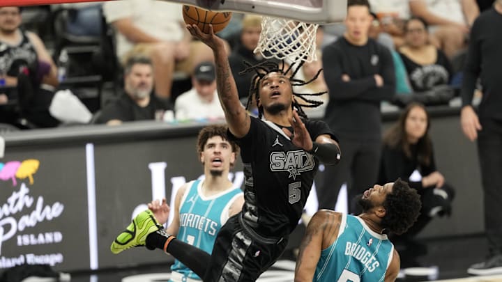Mar 14, 2025; San Antonio, Texas, USA; San Antonio Spurs guard Stephon Castle (5) drives to the basket over Charlotte Hornets forward Miles Bridges (0) during the second half at Frost Bank Center. Mandatory Credit: Scott Wachter-Imagn Images