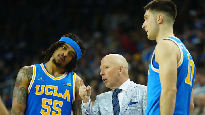 Mar 8, 2025; Los Angeles, California, USA; UCLA Bruins head coach Mick Cronin (center) talks with guard Skyy Clark (55) and guard Lazar Stefanovic (10) in the second half against the Southern California Trojans at Pauley Pavilion presented by Wescom. Mandatory Credit: Kirby Lee-Imagn Images