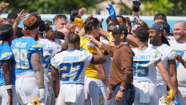 Jun 13, 2024; Costa Mesa, CA, USA; Los Angeles Chargers coach Jim Harbaugh joins hands in a huddle with tight end Donald Parham Jr. (89), running back J.K. Dobbins (27), quarterback Justin Herbert (10) and receiver Ladd McConkey (15) during minicamp at the Hoag Performance Center. Mandatory Credit: Kirby Lee-USA TODAY Sports Jun 13, 2024; Costa Mesa, CA, USA; Los Angeles Chargers coach Jim Harbaugh joins hands in a huddle with tight end Donald Parham Jr. (89), running back J.K. Dobbins (27), quarterback Justin Herbert (10) and receiver Ladd McConkey (15) during minicamp at the Hoag Performance Center. Mandatory Credit: Kirby Lee-USA TODAY Sports