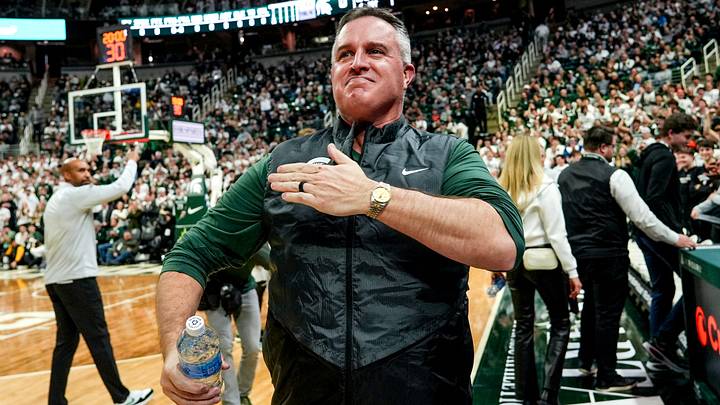 Michigan State's new football coach Pat Fitzgerald pats his heart at the crowd in attendance for the Spartans basketball game against Iowa Michigan State's new football coach Pat Fitzgerald pats his heart at the crowd in attendance for the Spartans basketball game against Iowa