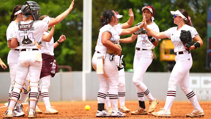 Mississippi State softball players high-five each other at the end of an inning during the 2024 season.