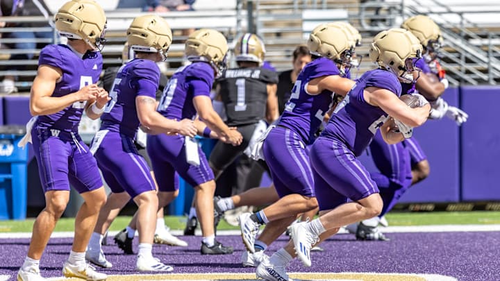 Husky quarterbacks and running backs go through a spring drill. 