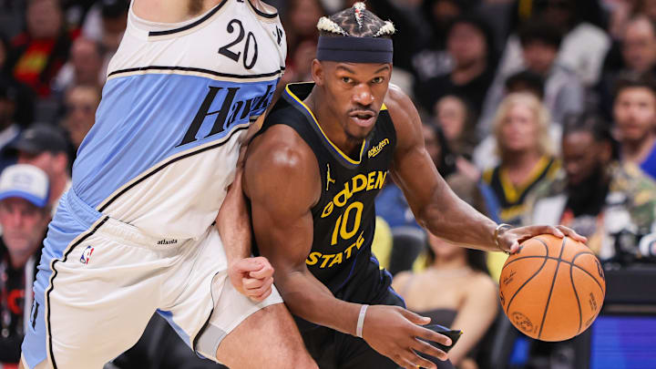 Mar 22, 2025; Atlanta, Georgia, USA; Golden State Warriors forward Jimmy Butler III (10) drives on Atlanta Hawks forward Georges Niang (20) in the fourth quarter at State Farm Arena. Mandatory Credit: Brett Davis-Imagn Images