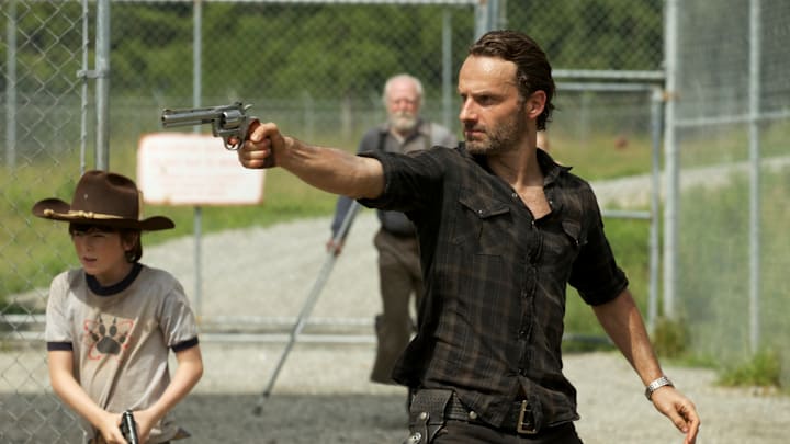Carl Grimes (Chandler Riggs) and Rick Grimes (Andrew Lincoln) - (Background) Hershel Greene (Scott Wilson) - The Walking Dead_Season 3, Episode 7_"When the Dead Come Knocking" - Photo Credit: Blake Tyers/AMC