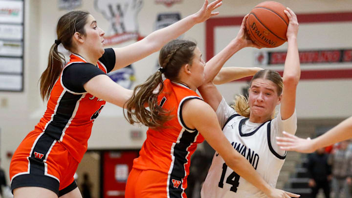 Shawano High School senior Leah Nordin (14) fights to maintain possession versus West De Pere's Mia Racine (4) and Alexa Rattray (1) in a game on Tuesday, January 28, 2025.
