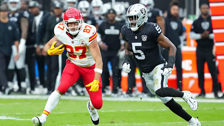 Oct 27, 2024; Paradise, Nevada, USA; Kansas City Chiefs tight end Travis Kelce (87) looks to evade the tackle of Las Vegas Raiders linebacker Divine Deablo (5) during the first quarter at Allegiant Stadium. Mandatory Credit: Stephen R. Sylvanie-Imagn Images