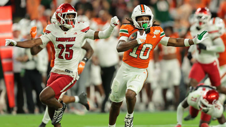 Miami wide receiver Malachi Toney (10) carries the football against Louisville defensive back Tayon Holloway (25)