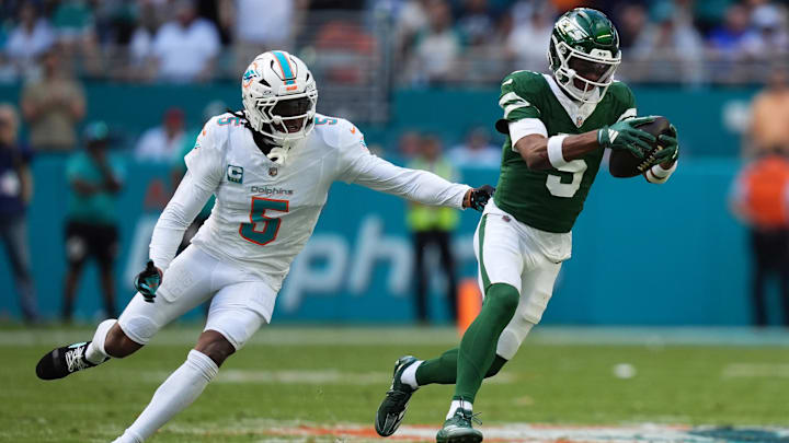 Dec 8, 2024; Miami Gardens, Florida, USA; New York Jets wide receiver Garrett Wilson (5) runs with the ball away from Miami Dolphins cornerback Jalen Ramsey (5) during the first half at Hard Rock Stadium. Mandatory Credit: Jasen Vinlove-Imagn Images