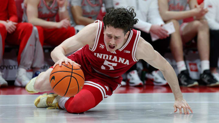 Mar 7, 2026; Columbus, Ohio, USA; Indiana Hoosiers forward Tucker Devries (12) goes to the floor for a loose ball during the first half against the Ohio State Buckeyes at Value City Arena. Mandatory Credit: Joseph Maiorana-Imagn Images
