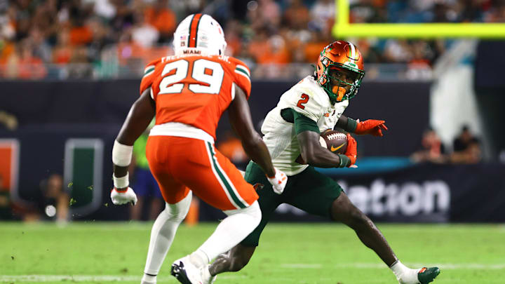 Sep 7, 2024; Miami Gardens, Florida, USA; Florida A&M Rattlers wide receiver Jamari Gassett (2) runs with the football against Miami Hurricanes defensive back OJ Frederique Jr. (29) during the third quarter at Hard Rock Stadium. Mandatory Credit: Sam Navarro-Imagn Images Sep 7, 2024; Miami Gardens, Florida, USA; Florida A&M Rattlers wide receiver Jamari Gassett (2) runs with the football against Miami Hurricanes defensive back OJ Frederique Jr. (29) during the third quarter at Hard Rock Stadium. Mandatory Credit: Sam Navarro-Imagn Images