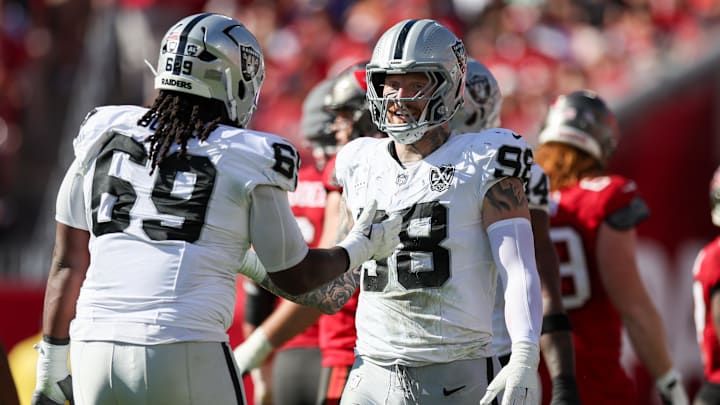Dec 8, 2024; Tampa, Florida, USA; Las Vegas Raiders defensive end Maxx Crosby (98) and defensive tackle Adam Butler (69) reacts after a play against the Tampa Bay Buccaneers in the second quarter at Raymond James Stadium. Mandatory Credit: Nathan Ray Seebeck-Imagn Images
