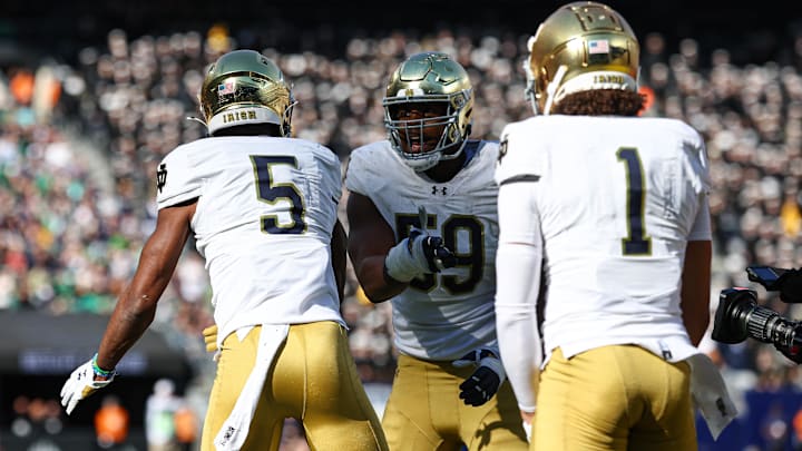 Oct 26, 2024; East Rutherford, New Jersey, USA; Notre Dame Fighting Irish defensive lineman Boubacar Traore (5) celebrates his intercept with teammates during the second half against the Navy Midshipmen at MetLife Stadium. Mandatory Credit: Vincent Carchietta-Imagn Images Oct 26, 2024; East Rutherford, New Jersey, USA; Notre Dame Fighting Irish defensive lineman Boubacar Traore (5) celebrates his intercept with teammates during the second half against the Navy Midshipmen at MetLife Stadium. Mandatory Credit: Vincent Carchietta-Imagn Images