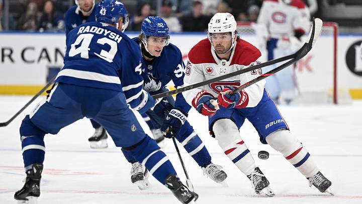 Montreal Canadiens forward Alex Newhook (15) clears the puck as Toronto Maple Leafs defenseman Darren Raddysh (43) and forward Gavin McKenna (92) defend in the second period at Scotiabank Arena.  Mandatory Credit: Dan Hamilton-Imagn Images