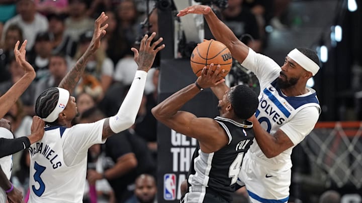 May 12, 2026; San Antonio, Texas, USA; San Antonio Spurs guard De’Aaron Fox (4) drives to the basket against Minnesota Timberwolves guard Mike Conley (10) and forward Jaden McDaniels (3) during the first half of Game 5 of the second round of the 2026 NBA Playoffs at Frost Bank Center.