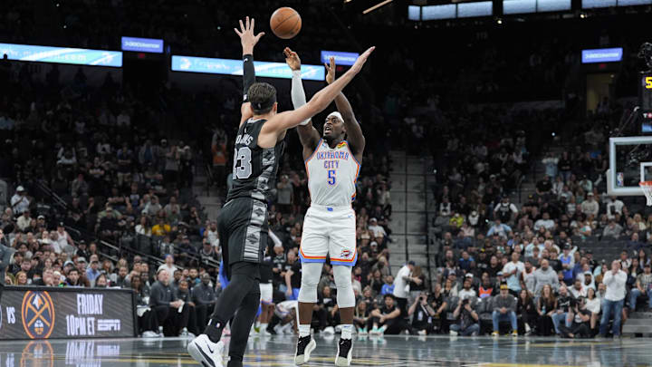 Nov 19, 2024; San Antonio, Texas, USA;  Oklahoma City Thunder guard Luguentz Dort (5) shoots over San Antonio Spurs forward Zach Collins (23) in the second half at Frost Bank Center. Mandatory Credit: Daniel Dunn-Imagn Images