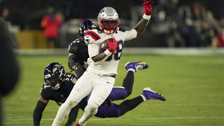 Dec 21, 2025; Baltimore, Maryland, USA;  New England Patriots running back Rhamondre Stevenson (38) runs the ball against Baltimore Ravens safety Alohi Gilman (12) and linebacker Trenton Simpson (32) during the second half of the game at M&T Bank Stadium. Mandatory Credit: Mitch Stringer-Imagn Images
