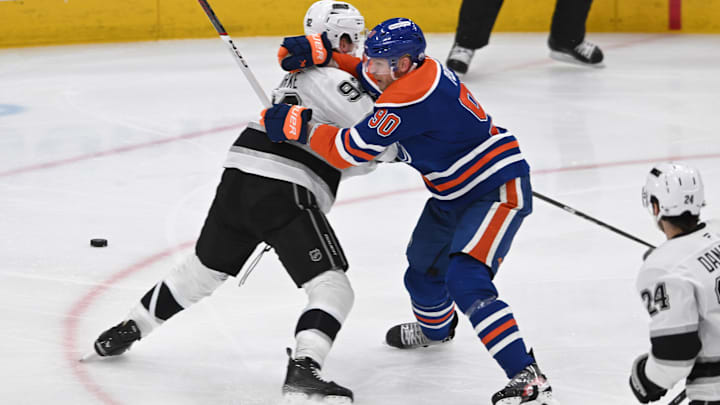 Apr 14, 2025; Edmonton, Alberta, CAN; Los Angeles Kings defenseman Brandt Clarke (92) tangles with Edmonton Oilers right winger Corey Perry (90) during the second period at Rogers Place. Mandatory Credit: Walter Tychnowicz-Imagn Images