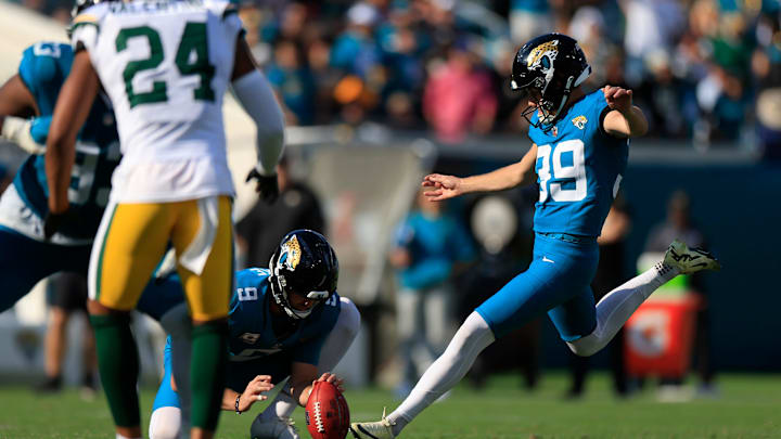 Jacksonville Jaguars place kicker Cam Little (39) kicks a game-tying point after try as punter Logan Cooke (9) holds during the fourth quarter of an NFL football matchup Sunday, Oct. 27, 2024 at EverBank Stadium in Jacksonville, Fla. The Packers edged the Jaguars 30-27 on a last-second field goal. [Corey Perrine/Florida Times-Union]