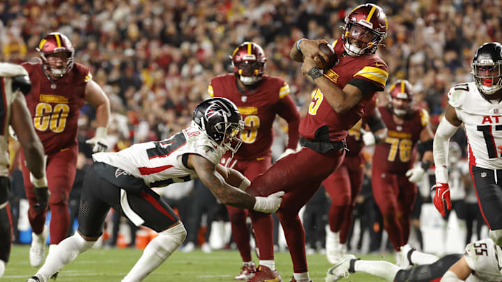 Jayden Daniels tries to elude tacklers at the the goal line in Sunday night's Washington win over Atlanta.