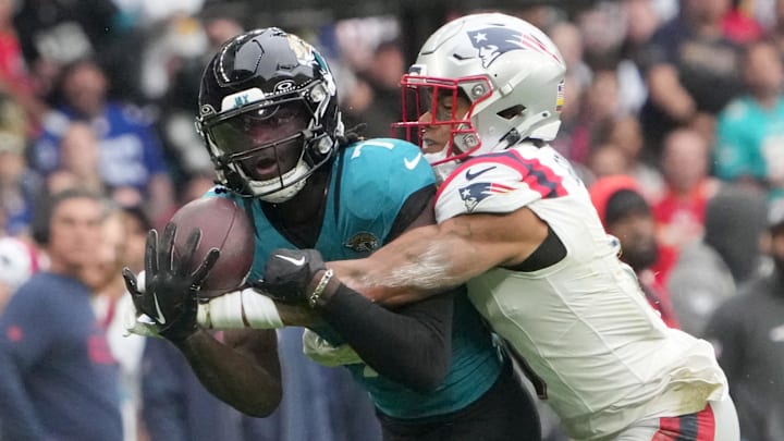 Oct 20, 2024; London, United Kingdom; Jacksonville Jaguars wide receiver Brian Thomas Jr. (7) catches a 58-yard pass against New England Patriots cornerback Christian Gonzalez (0) in the first half of an NFL International Series game at Wembley Stadium. Mandatory Credit: Kirby Lee-Imagn Images