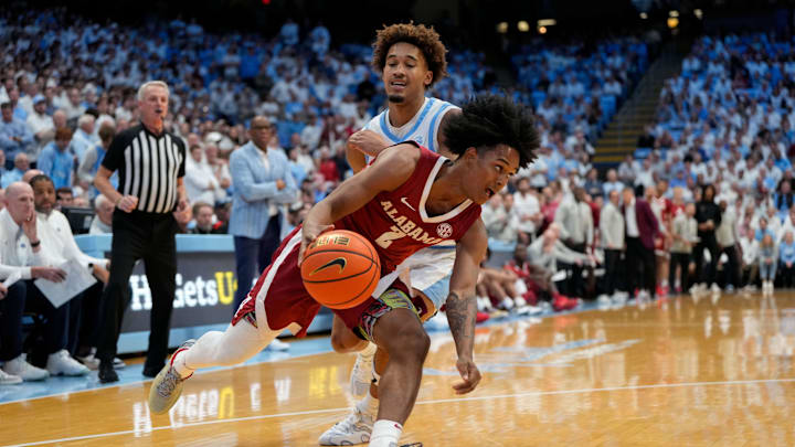 Dec 4, 2024; Chapel Hill, North Carolina, USA; Alabama Crimson Tide guard Aden Holloway (2) drives as North Carolina Tar Heels guard Seth Trimble (7) defends in the first half at Dean E. Smith Center. Mandatory Credit: Bob Donnan-Imagn Images