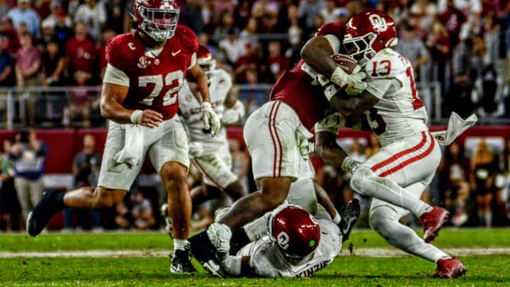 Oklahoma defensive back Reggie Powers III and linebacker Kobie McKinzie combine to make a tackle against Alabama. 