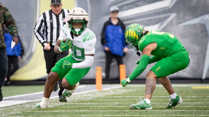 Oregon White Team running back Jordan James looks for a gap under cover from defensive back Kobe Savage during the Oregon Ducks’ Spring Game Saturday, April 27. 2024 at Autzen Stadium in Eugene, Ore.
