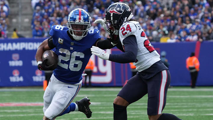 Saquon Barkley of the Giants running the ball against Derek Stingley Jr. of the Texans in the first