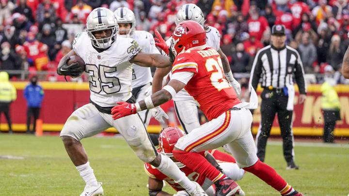 Dec 25, 2023; Kansas City, Missouri, USA; Las Vegas Raiders running back Zamir White (35) runs the ball as Kansas City Chiefs safety Mike Edwards (21) attempts the tackle during the second half at GEHA Field at Arrowhead Stadium. Mandatory Credit: Denny Medley-USA TODAY Sports