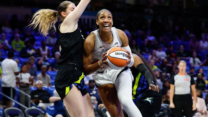 Jul 27, 2025; Arlington, Texas; Las Vegas Aces center A'ja Wilson (22) drives to the basket against Dallas Wings center Luisa Geiselsoder (18) during the first half at College Park Center. 