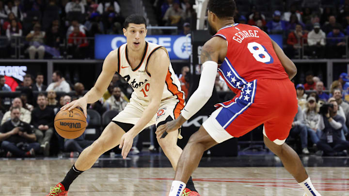 Feb 7, 2025; Detroit, Michigan, USA;  Detroit Pistons forward Simone Fontecchio (19) dribbles defended by Philadelphia 76ers forward Paul George (8) in the second half at Little Caesars Arena. Mandatory Credit: Rick Osentoski-Imagn Images