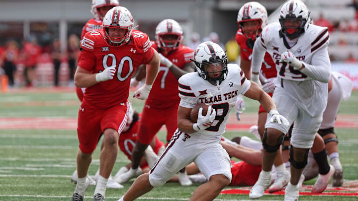 Sep 20, 2025; Salt Lake City, Utah, USA; Texas Tech Red Raiders running back Cameron Dickey (8) runs the ball against Utah Utes defensive end John Henry Daley (90) during the fourth quarter at Rice-Eccles Stadium. Mandatory Credit: Rob Gray-Imagn Images