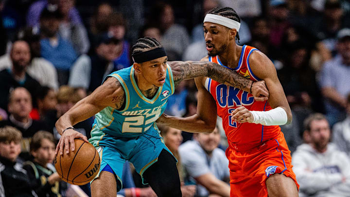 Apr 7, 2024; Charlotte, North Carolina, USA; Charlotte Hornets guard Tre Mann (23) drives around Oklahoma City Thunder guard Shai Gilgeous-Alexander (2) during the first quarter at Spectrum Center. Mandatory Credit: Scott Kinser-Imagn Images