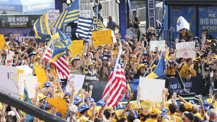 Aug 31, 2024; Morgantown, West Virginia, USA; Fans cheer during the Big Noon Kickoff show outside of Mountaineer Field at Milan Puskar Stadium. 