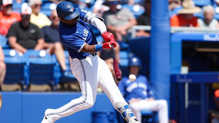 Mar 13, 2025: Toronto Blue Jays second baseman Orelvis Martinez (13) hits a base hit against the Baltimore Orioles in the second inning during spring training at TD Ballpark.