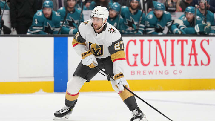 Jan 7, 2025; San Jose, California, USA; Vegas Golden Knights defenseman Shea Theodore (27) skates with the puck against the San Jose Sharks during the first period at SAP Center at San Jose. Mandatory Credit: Darren Yamashita-Imagn Images