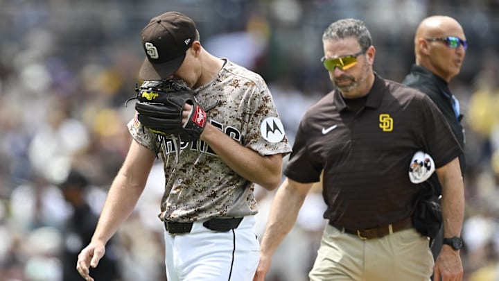Apr 12, 2026; San Diego, California, USA; San Diego Padres starting pitcher Nick Pivetta (27), left, leaves the field with a trainer during the fourth inning against the Colorado Rockies at Petco Park. Mandatory Credit: Denis Poroy-Imagn Images