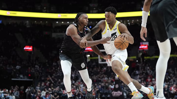 Dec 6, 2024; Portland, Oregon, USA; Utah Jazz forward Brice Sensabaugh (28) dribbles the ball against Portland Trail Blazers forward Jabari Walker (34, left) during the second half at Moda Center. Mandatory Credit: Soobum Im-Imagn Images