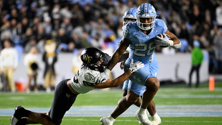 Nov 16, 2024; Chapel Hill, North Carolina, USA;  North Carolina Tar Heels running back Omarion Hampton (28) runs as Wake Forest Demon Deacons defensive back Nick Andersen (45) defends in the third quarter at Kenan Memorial Stadium.  