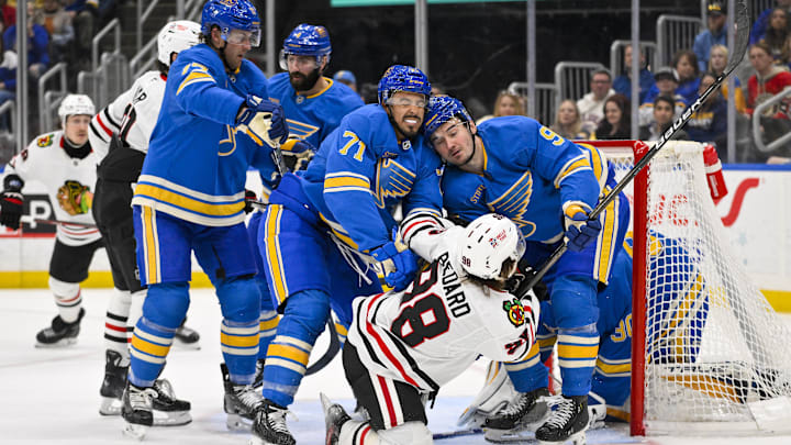 Mar 22, 2025; St. Louis, Missouri, USA;  St. Louis Blues right wing Mathieu Joseph (71) and center Alexandre Texier (9) defend against Chicago Blackhawks center Connor Bedard (98) during the third period at Enterprise Center. Mandatory Credit: Jeff Curry-Imagn Images