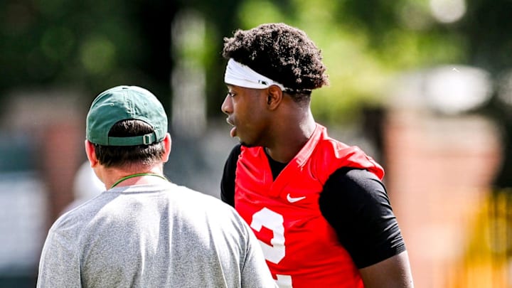 Michigan State quarterback Aidan Chiles, right, talks with head coach Jonathan Smith during the first day of football camp on Tuesday, July 30, 2024, in East Lansing.