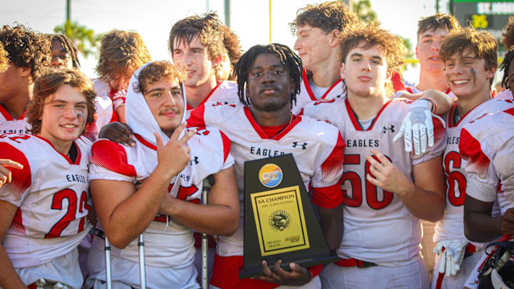 Members of the Jupiter Christian football team pose with the 2024 SSAA Class 5A state championship trophy.
