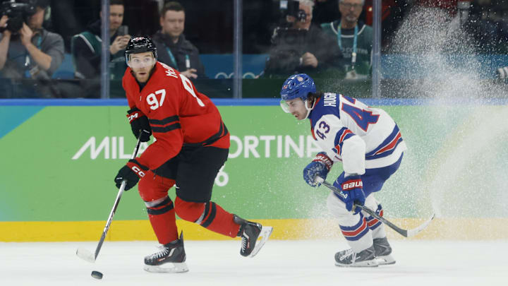 Feb 22, 2026; Milan, Italy; Connor McDavid (97) of Canada in action against Quinn Hughes (43) of the United States in the men's ice hockey gold medal game during the Milano Cortina 2026 Olympic Winter Games at Milano Santagiulia Ice Hockey Arena. Mandatory Credit: Geoff Burke-Imagn Images