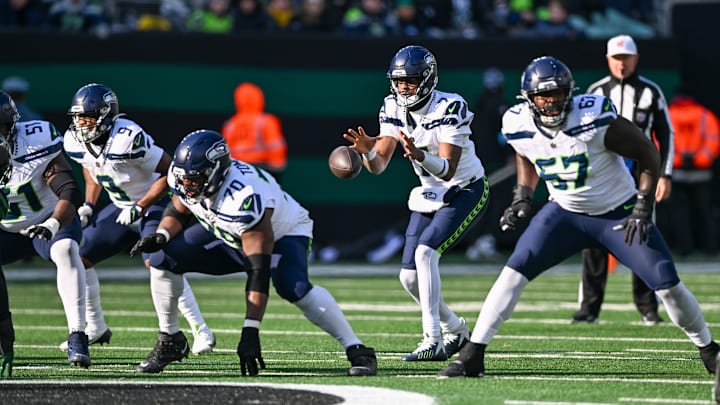 Dec 1, 2024; East Rutherford, New Jersey, USA; Seattle Seahawks guard Laken Tomlinson (70) snaps the ball to Seattle Seahawks quarterback Geno Smith (7) during the third quarter against the New York Jets at MetLife Stadium. 