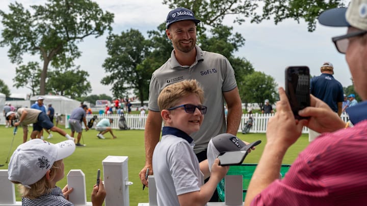 PGA Tour Pro Wyndham Clark, smiles as he takes a photo with a fan during the Rocket Classic Pro-Am in Detroit on Wednesday, June 25, 2025.