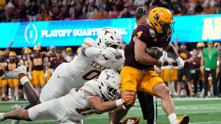 Arizona State running back Cam Skattebo (4) runs past Texas linebacker Anthony Hill Jr. (0) and Texas linebacker Liona Lefau (18) during the third quarter of the Chick-fil-A Peach Bowl in Atlanta on Wednesday, Jan. 1, 2025.