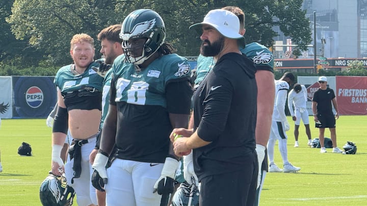 Retired Eagles center Jason Kelce (white hat) has been spending time at training camp, helping develop the younger offensive linemen.